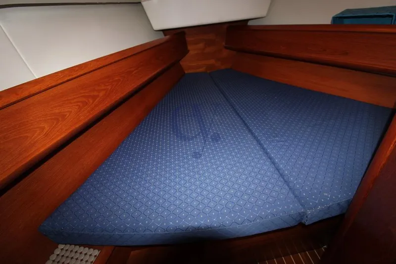  Yacht Photos Pics Interior cabin of 2004 Jeanneau Sun Odyssey 40.3 with blue mattress and wooden finish.