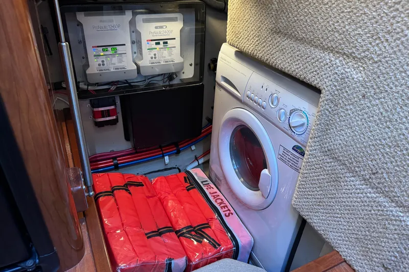  Yacht Photos Pics Laundry area with washer, life jackets, and electrical panels on 2004 Sea Ray 390 Motor Yacht.