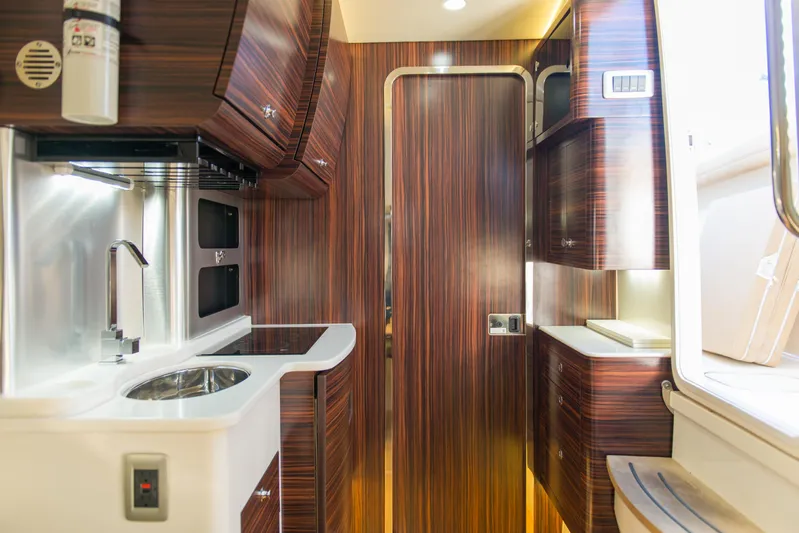  Yacht Photos Pics Interior of 2017 Scout 420 LXF boat with modern wood finish and compact kitchen area.