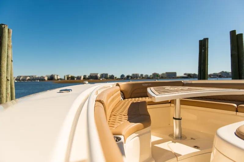  Yacht Photos Pics 2017 Scout 420 LXF boat interior with tan seating and table, docked by the water.