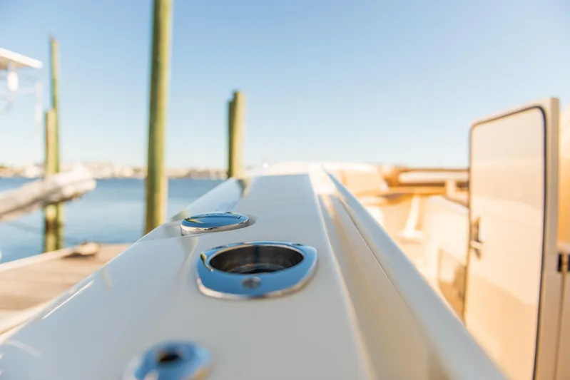  Yacht Photos Pics 2017 Scout 420 LXF boat detail with rod holders, docked by the water.