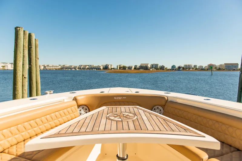  Yacht Photos Pics Bow view of 2017 Scout 420 LXF boat with luxurious seating and waterfront backdrop.