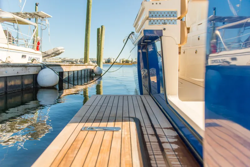  Yacht Photos Pics 2017 Scout 420 LXF yacht docked, showcasing sleek wooden deck and modern design.