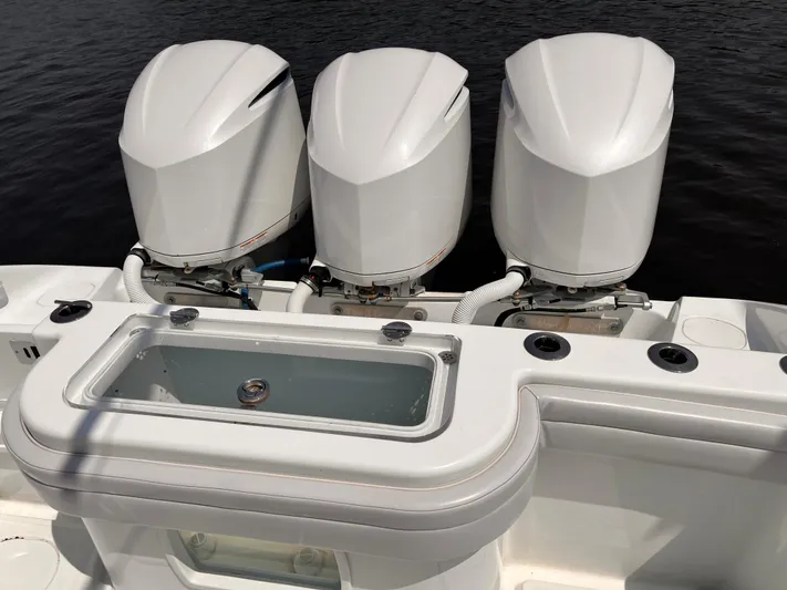  Yacht Photos Pics 2020 Yellowfin 36 boat with triple outboard engines and livewell, docked on calm water.