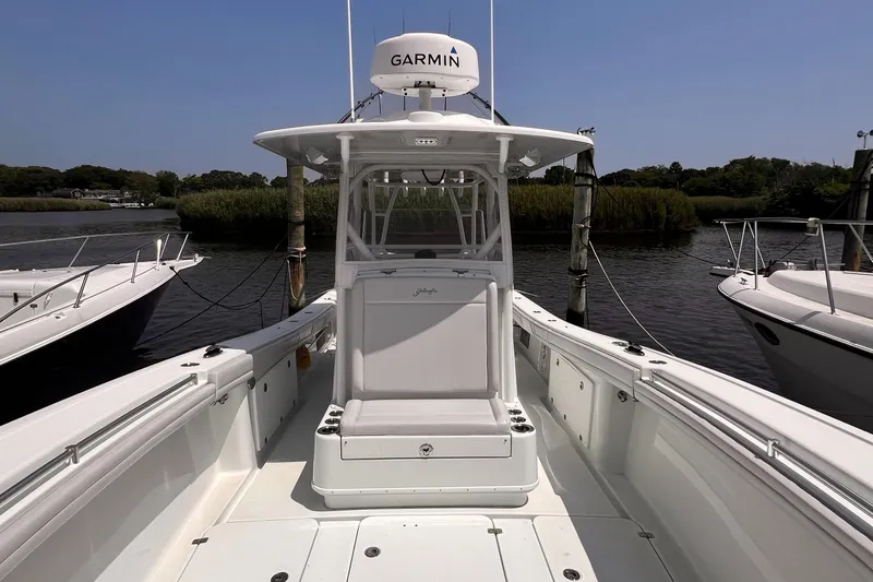  Yacht Photos Pics 2020 Yellowfin 36 boat docked, featuring Garmin equipment, surrounded by calm waters and greenery.