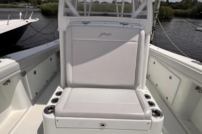  Yacht Photos Pics 2020 Yellowfin 36 boat interior with cushioned seating and cup holders, docked by the water.