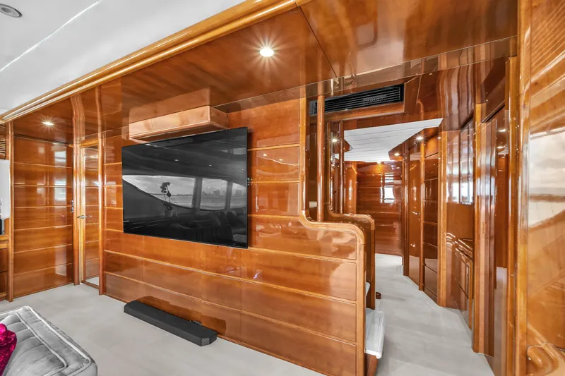 Sinpatico Yacht Photos Pics Luxurious interior of 2002 Ferretti Yachts Custom Line 94 with polished wood paneling and large TV.