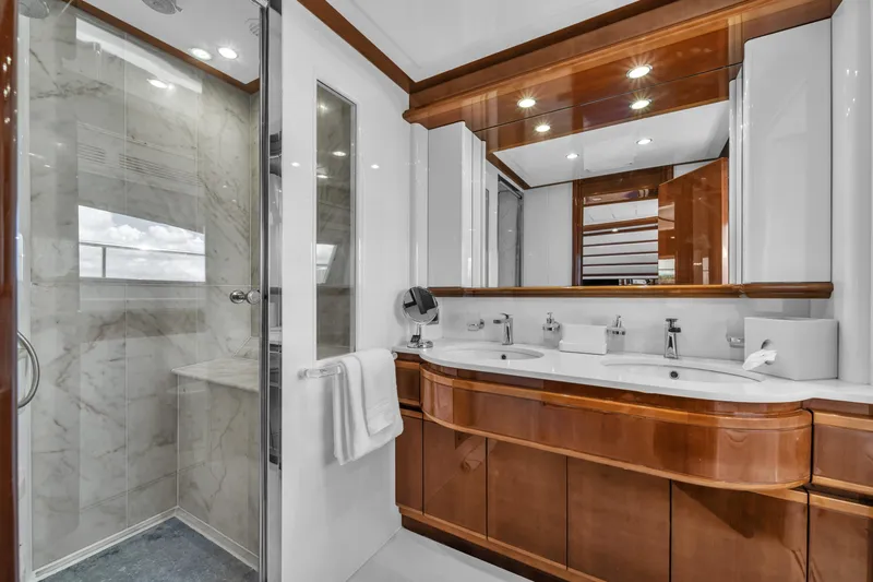 Sinpatico Yacht Photos Pics Luxurious bathroom on 2002 Ferretti Yachts Custom Line 94, featuring marble shower and elegant wood cabinetry.