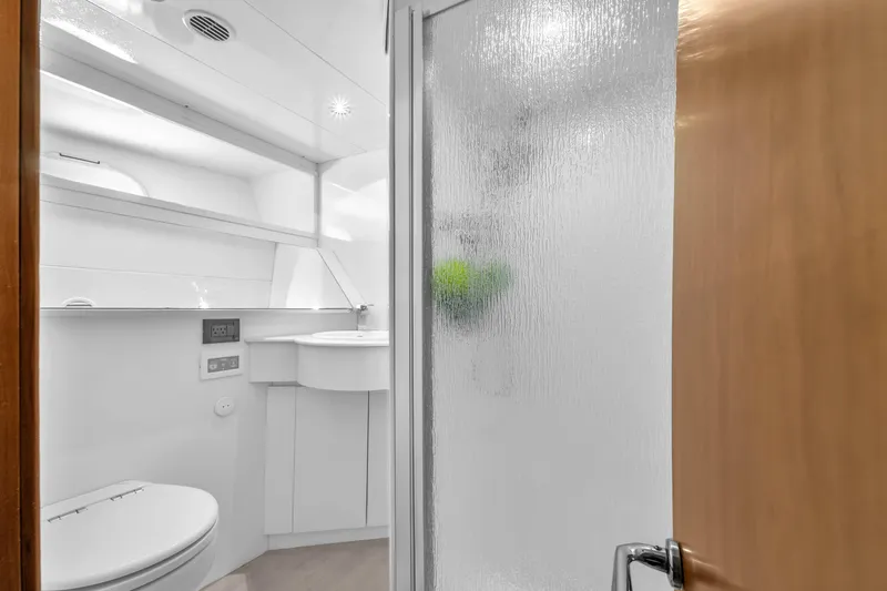 Sinpatico Yacht Photos Pics Luxurious bathroom in 2002 Ferretti Yachts Custom Line 94, featuring modern fixtures and frosted glass shower.