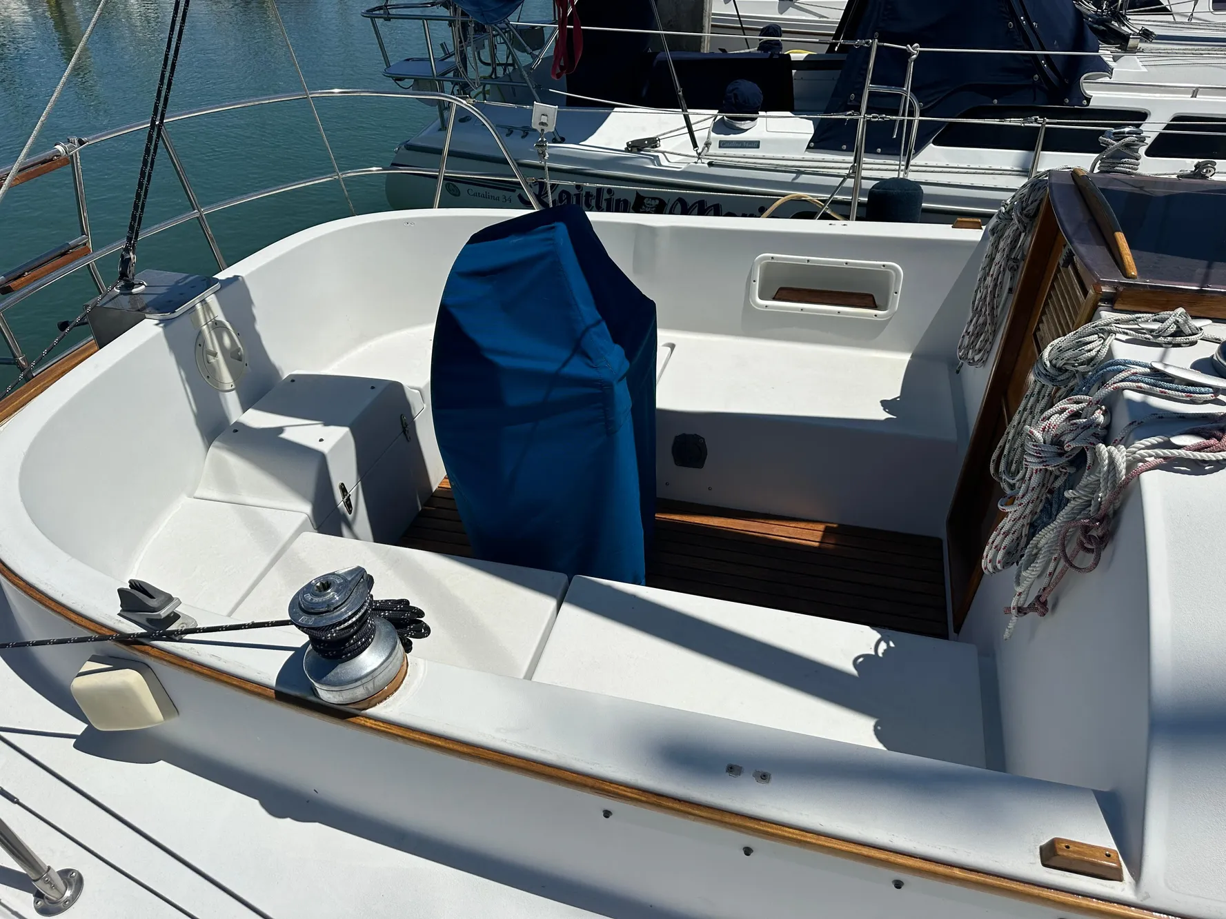 1986 Nonsuch Ultra sailboat cockpit with covered helm, docked in marina.