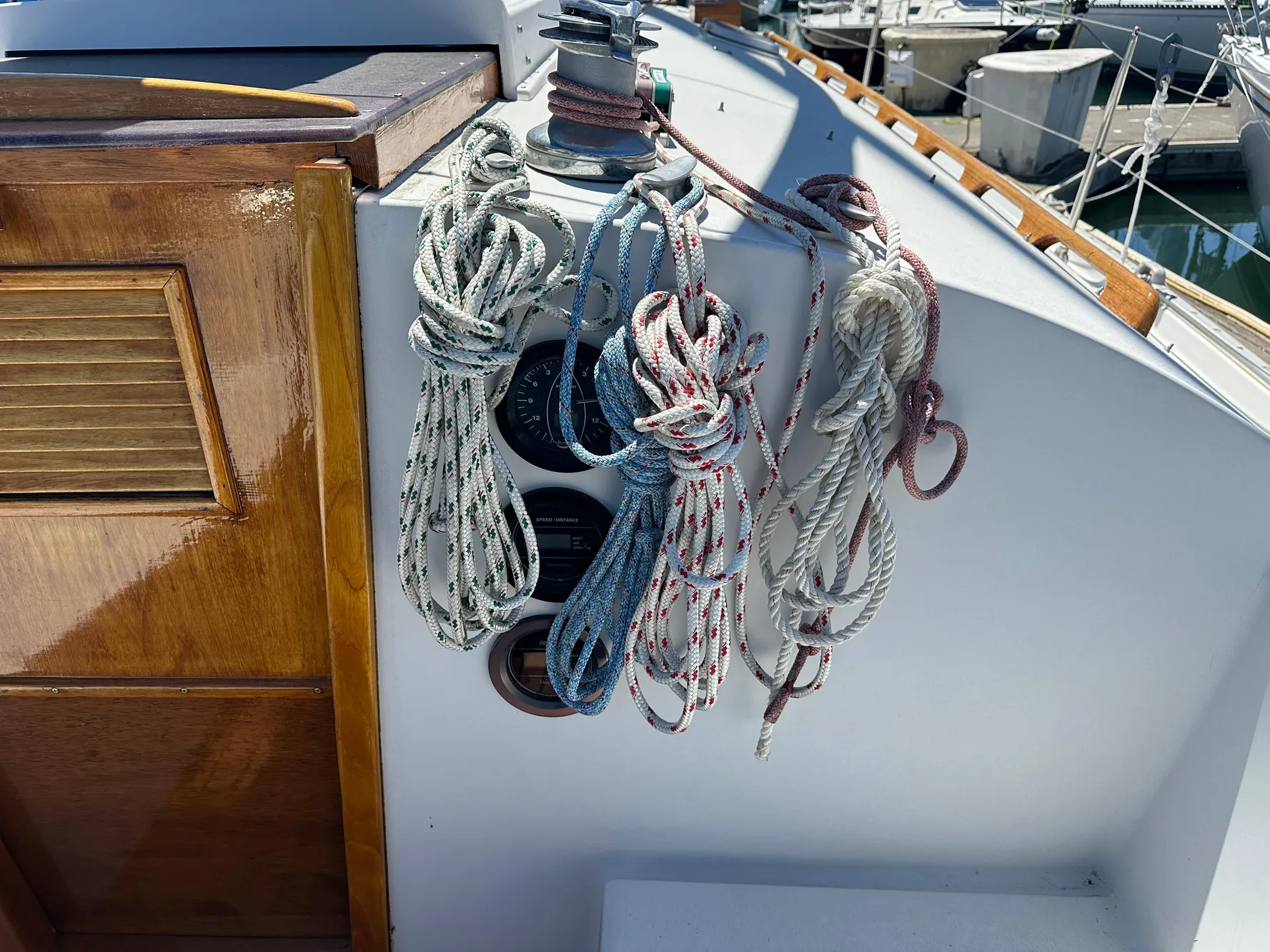 Coiled ropes on a 1986 Nonsuch Ultra sailboat deck near wooden hatch.