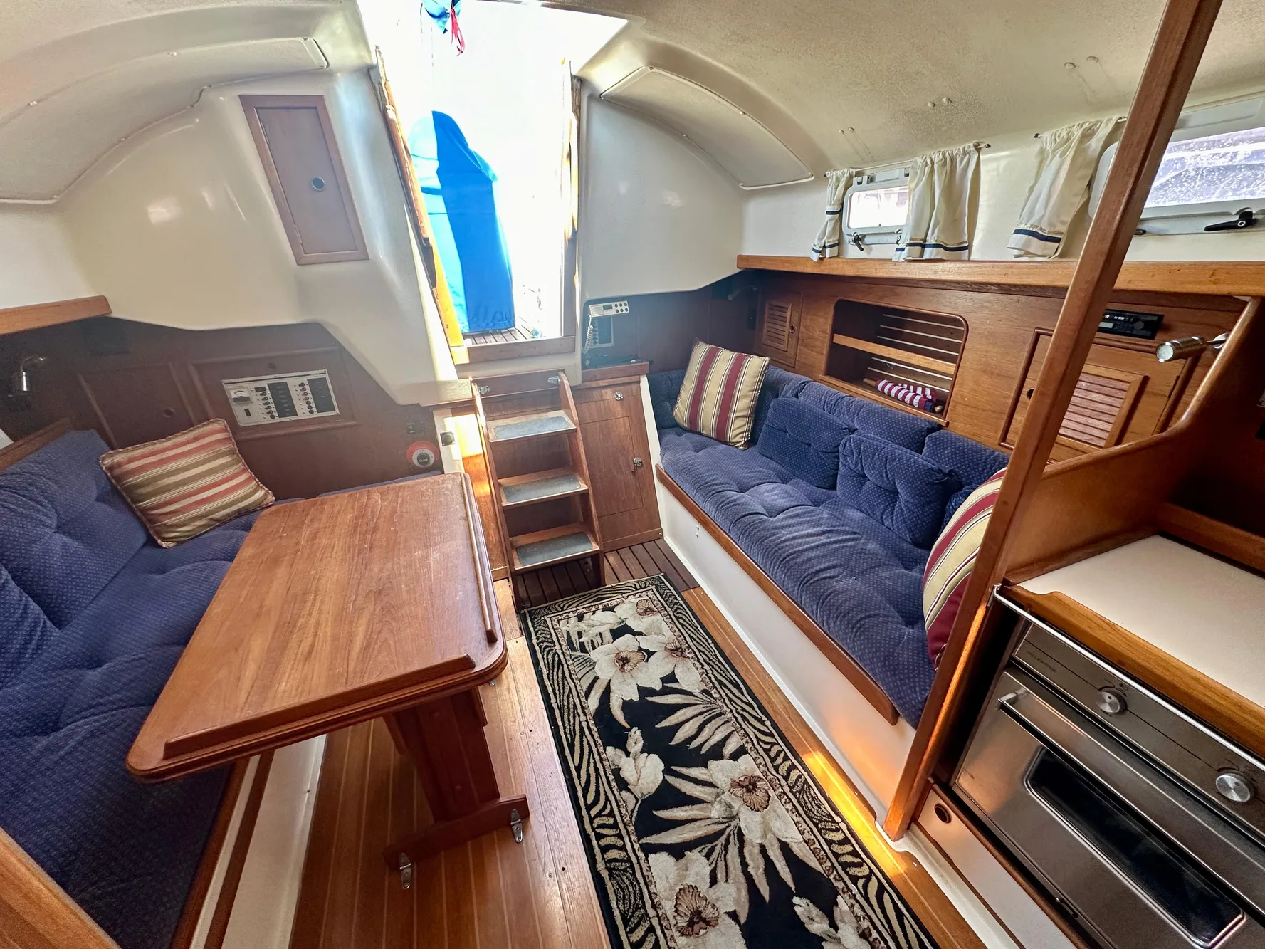 Interior of a 1986 Nonsuch Ultra sailboat with cozy seating and wooden finishes.