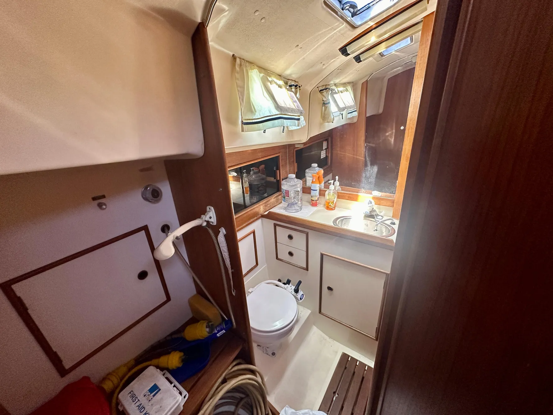 1986 Nonsuch Ultra yacht bathroom with sink, toilet, and storage cabinets.