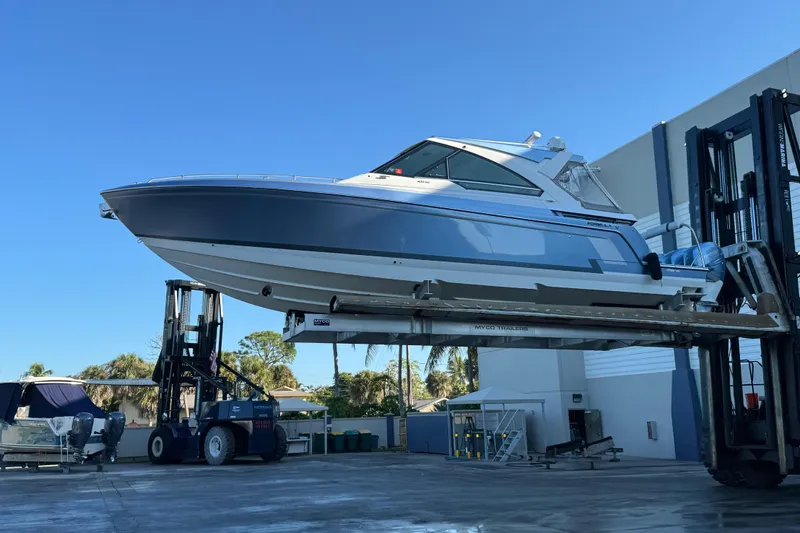 Millennium Falcon Yacht Photos Pics 2023 Formula 400 Super Sport Crossover boat lifted by forklift under clear blue sky.