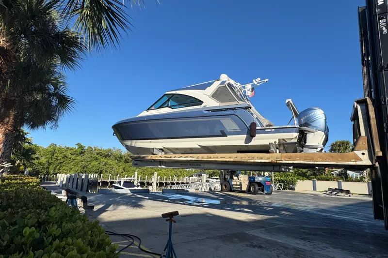 Millennium Falcon Yacht Photos Pics 2023 Formula 400 Super Sport Crossover boat on lift, surrounded by greenery.