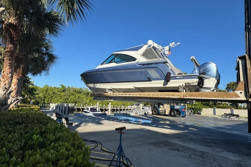 Millennium Falcon Yacht Photos Pics 2023 Formula 400 Super Sport Crossover boat on lift, surrounded by palm trees.