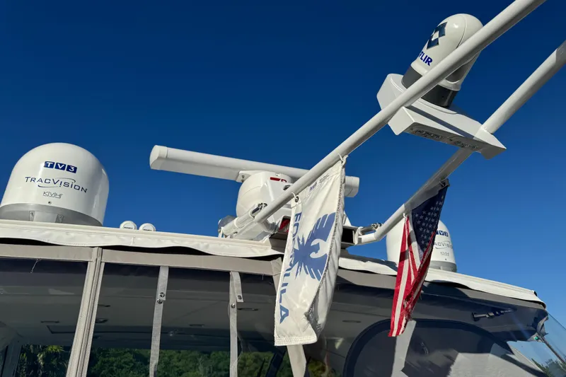 Millennium Falcon Yacht Photos Pics 2023 Formula 400 Super Sport Crossover with radar and flags under clear blue sky.