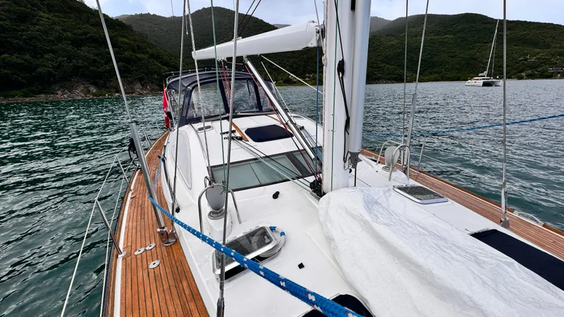 Cadence Yacht Photos Pics 2008 Jeanneau Sun Odyssey 54 DS sailboat on calm waters, surrounded by lush hills.