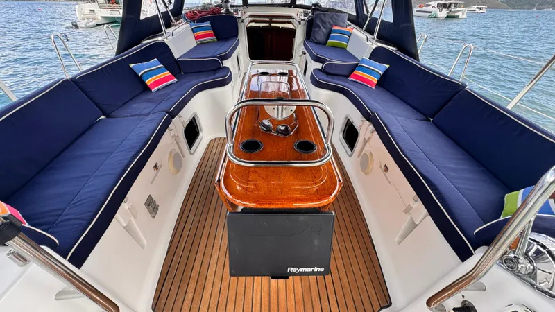 Cadence Yacht Photos Pics Jeanneau Sun Odyssey 54 DS 2008 yacht cockpit with blue seating and wooden table.