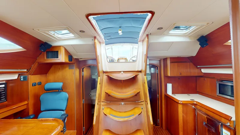 Cadence Yacht Photos Pics Interior of 2008 Jeanneau Sun Odyssey 54 DS yacht, featuring wooden cabinetry and seating.