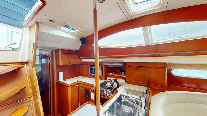 Cadence Yacht Photos Pics Interior of 2008 Jeanneau Sun Odyssey 54 DS yacht, featuring a modern kitchen and seating area.