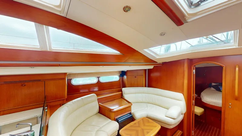 Cadence Yacht Photos Pics Luxurious interior of 2008 Jeanneau Sun Odyssey 54 DS yacht with plush seating and wood finish.
