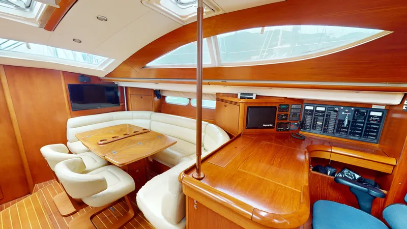 Cadence Yacht Photos Pics Luxurious interior of 2008 Jeanneau Sun Odyssey 54 DS yacht with wood finish and seating area.