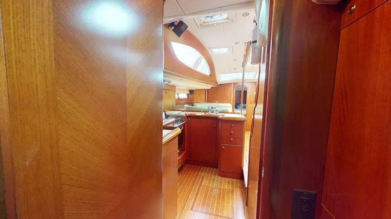 Cadence Yacht Photos Pics Interior of 2008 Jeanneau Sun Odyssey 54 DS yacht, featuring wooden cabinetry and flooring.