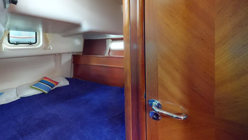 Cadence Yacht Photos Pics Cozy cabin interior of 2008 Jeanneau Sun Odyssey 54 DS with blue bedding and wooden accents.