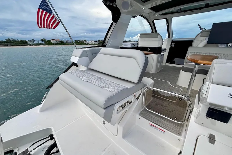  Yacht Photos Pics 2022 Sea Ray Sundancer 370 Outboard interior with seating, table, and American flag.
