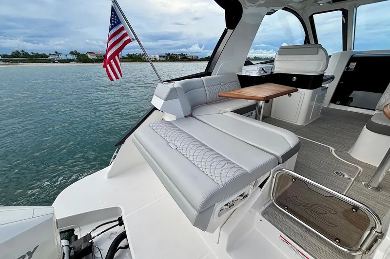  Yacht Photos Pics 2022 Sea Ray Sundancer 370 Outboard interior with seating, table, and American flag.