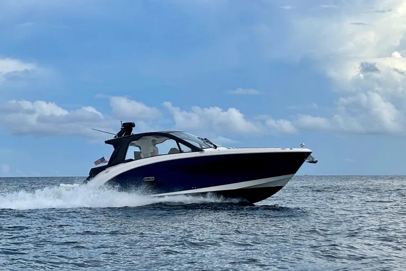  Yacht Photos Pics 2022 Sea Ray Sundancer 370 Outboard cruising on open water under a blue sky.