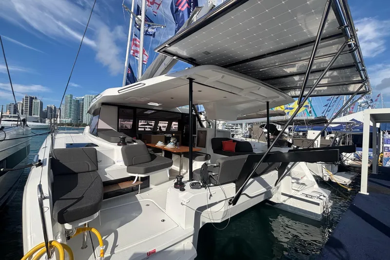 The Ilusion Yacht Photos Pics 2025 Fountaine Pajot 41 catamaran with modern seating and solar panels at a marina.