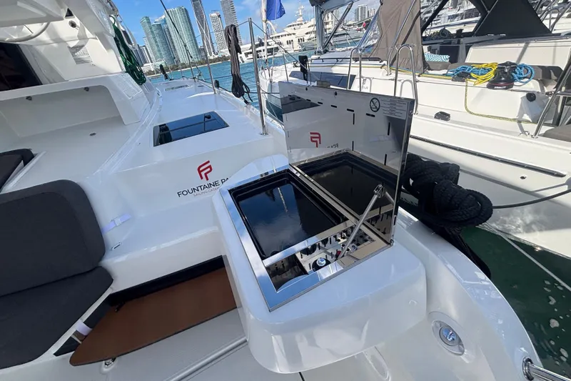 The Ilusion Yacht Photos Pics 2025 Fountaine Pajot 41 yacht deck with grill, docked in a marina.