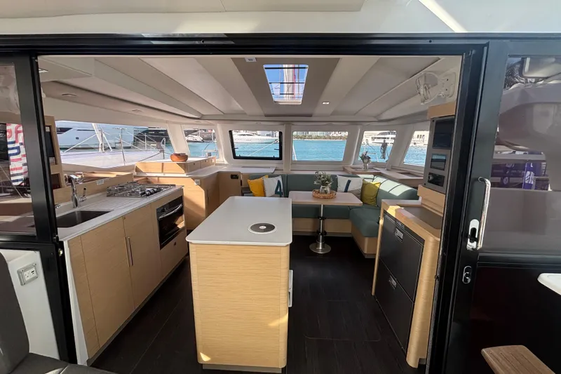 The Ilusion Yacht Photos Pics Modern interior of 2025 Fountaine Pajot 41 catamaran with kitchen and seating area.