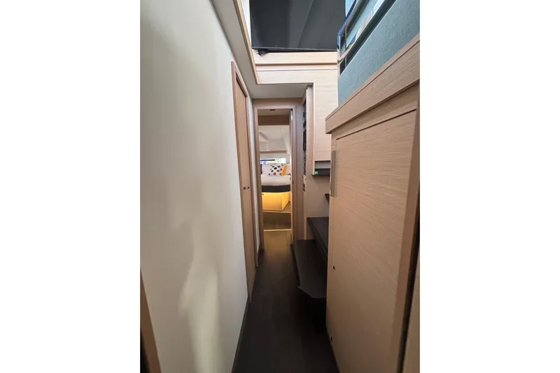 The Ilusion Yacht Photos Pics Interior hallway of 2025 Fountaine Pajot 41 yacht, featuring modern wood finishes.