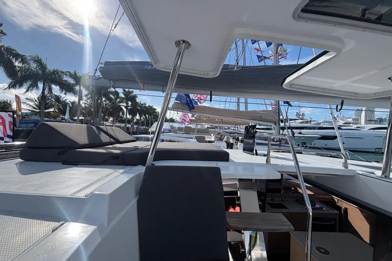 The Ilusion Yacht Photos Pics 2025 Fountaine Pajot 41 catamaran with sun deck, docked at marina under clear sky.