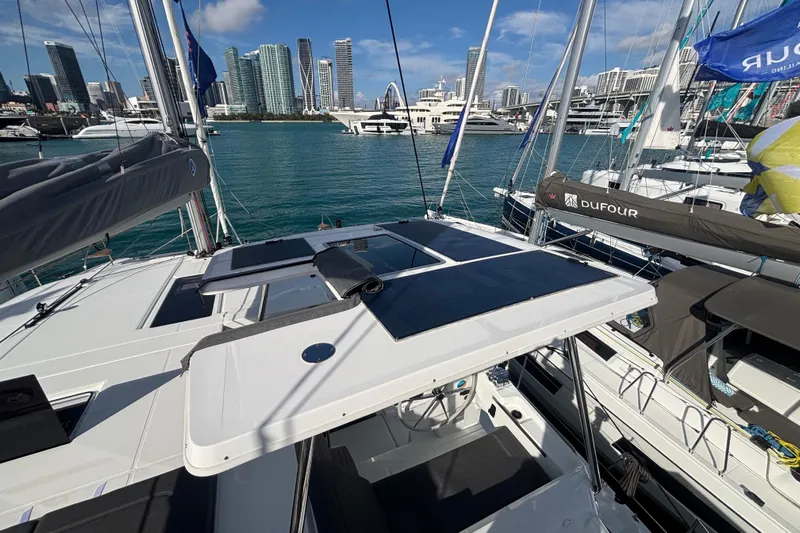The Ilusion Yacht Photos Pics 2025 Fountaine Pajot 41 catamaran docked in a marina with city skyline backdrop.
