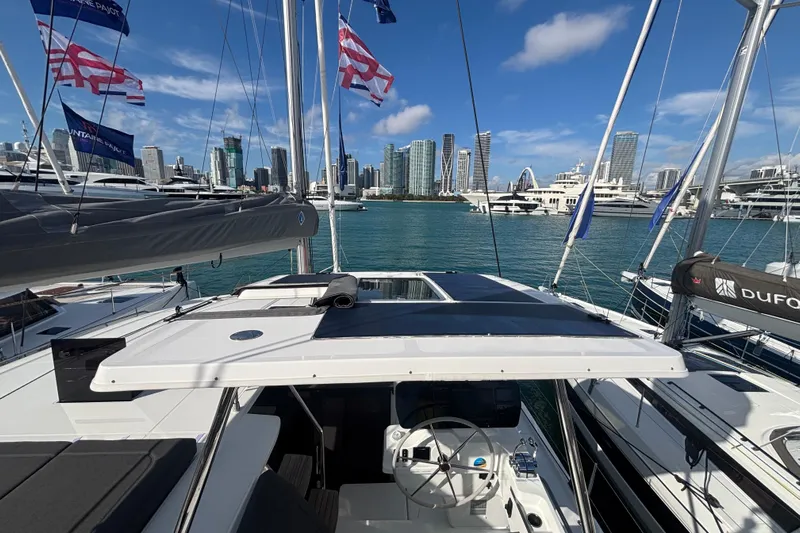 The Ilusion Yacht Photos Pics 2025 Fountaine Pajot 41 catamaran docked in marina with city skyline backdrop.
