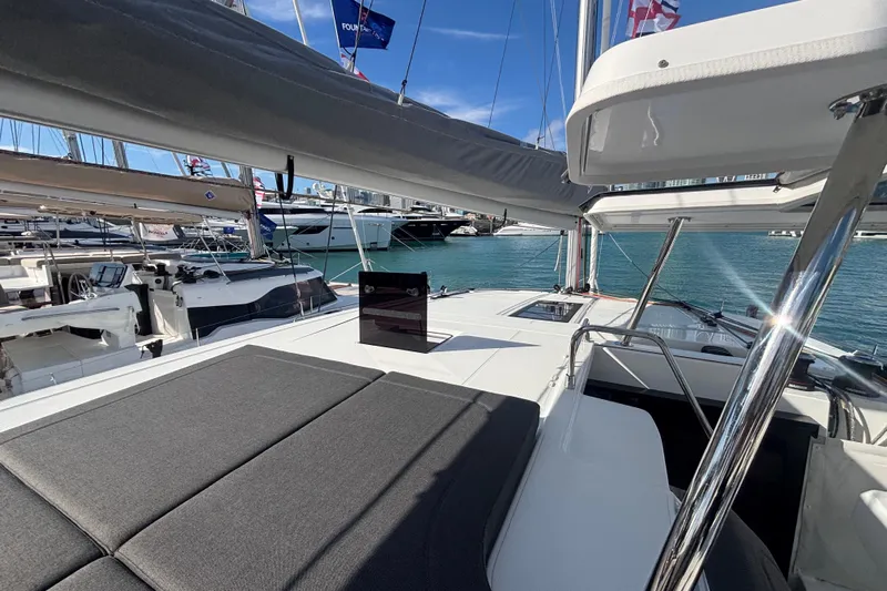 The Ilusion Yacht Photos Pics 2025 Fountaine Pajot 41 catamaran deck with sunbathing area and marina view.