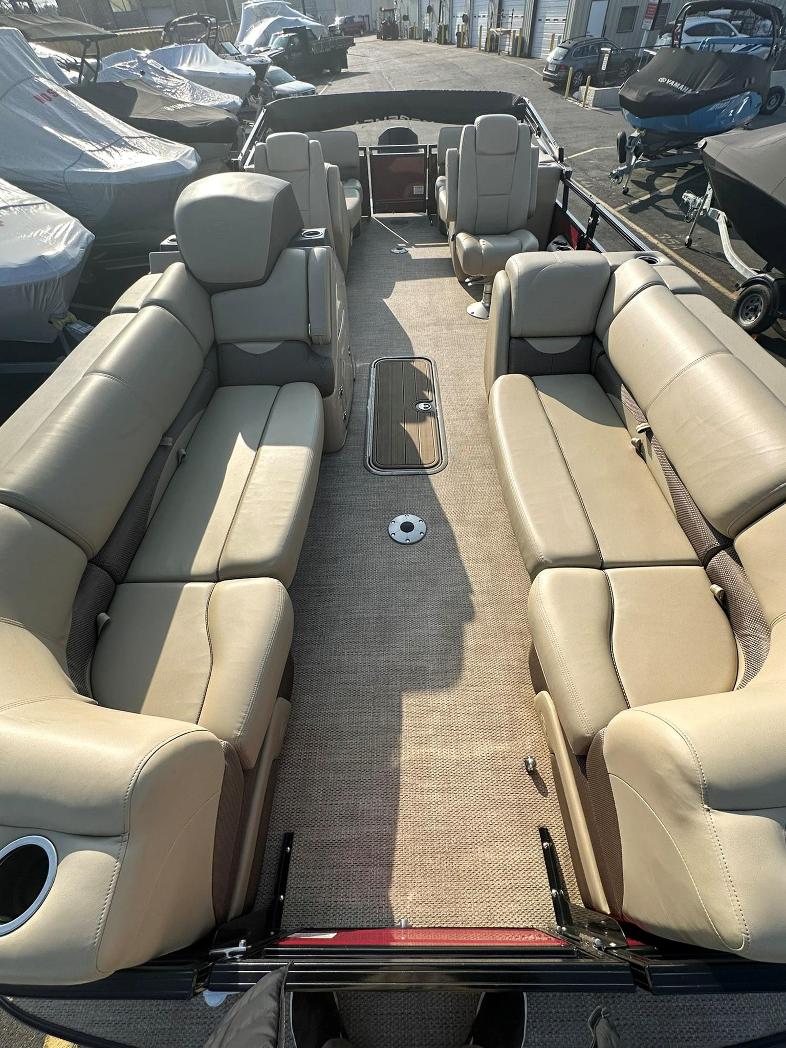 2023 Regency 230 DL3 pontoon boat with spacious beige seating and modern design.