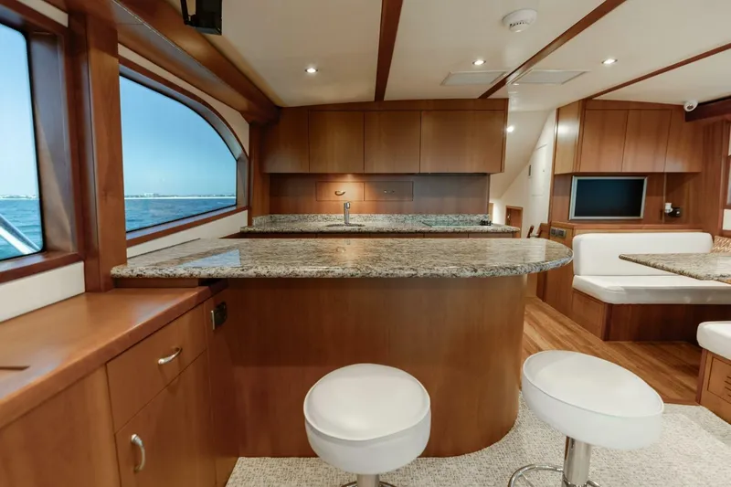  Yacht Photos Pics Luxurious interior of 2012 Hatteras 60 GT yacht with granite countertops and wooden cabinetry.
