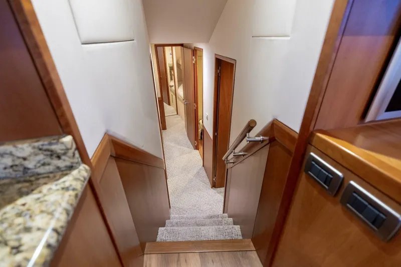  Yacht Photos Pics Interior view of 2012 Hatteras 60 GT yacht, featuring a carpeted staircase and wooden finishes.