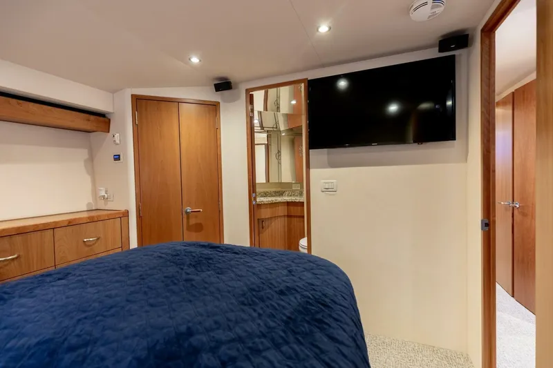  Yacht Photos Pics Luxurious cabin interior of 2012 Hatteras 60 GT yacht with TV and wooden furnishings.