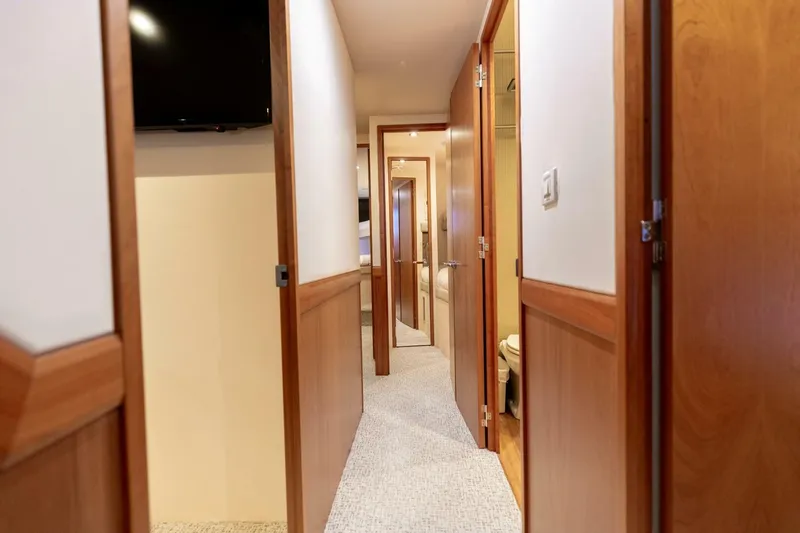  Yacht Photos Pics Hallway interior of 2012 Hatteras 60 GT yacht with wooden doors and carpet flooring.