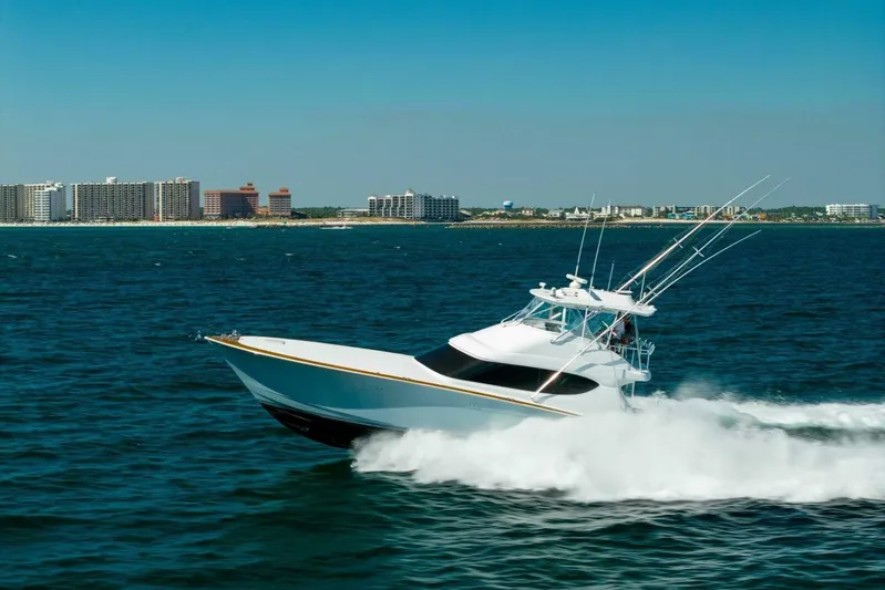  Yacht Photos Pics 2012 Hatteras 60 GT yacht cruising on ocean near coastal city skyline.
