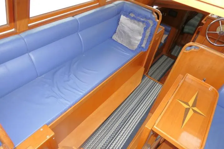 Sun Bird Yacht Photos Pics Interior of 2002 Tayana 460 Vancouver Pilothouse with blue seating and wooden accents.