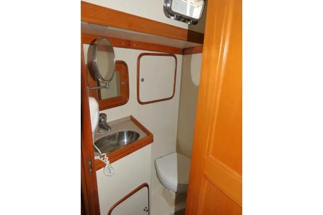 Sun Bird Yacht Photos Pics 2002 Tayana 460 Vancouver Pilothouse bathroom with sink, mirror, and toilet.