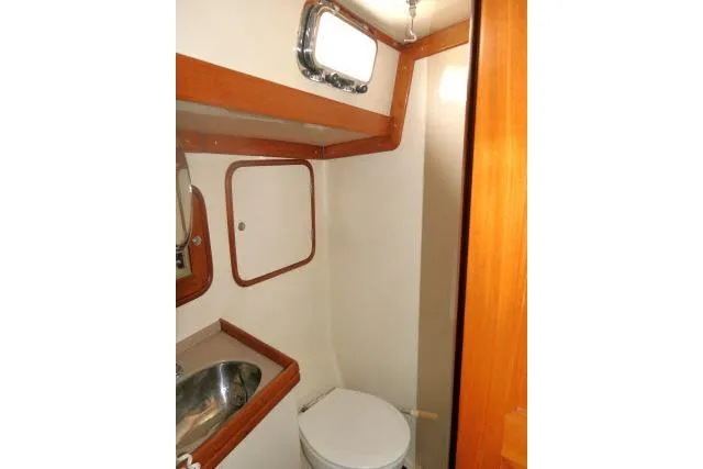 Sun Bird Yacht Photos Pics 2002 Tayana 460 Vancouver Pilothouse bathroom with sink, toilet, and wooden accents.