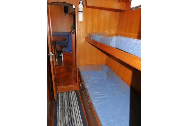 Sun Bird Yacht Photos Pics 2002 Tayana 460 Vancouver Pilothouse interior with wooden bunk beds and blue cushions.
